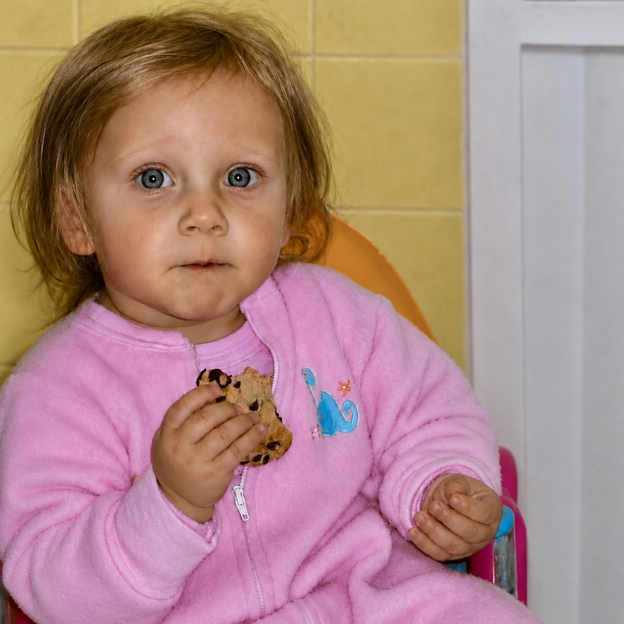 Emily as a toddler, eating a chocolate chip cookie